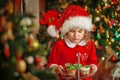 Merry Christmas - Little pretty girl in hat holding plate with cookies and candy for santa claus Royalty Free Stock Photo