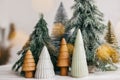 Merry Christmas. Christmas little trees and golden lights bokeh on white background. Winter magic forest, festive modern decor. Royalty Free Stock Photo