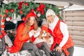 Merry Christmas and New Year party. Family in red winter clothes in car car trunk among decoration with dog Royalty Free Stock Photo