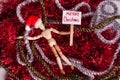 Merry Christmas picket sign held by jointed doll laying on a mess of red silver garland wearing a Santa hat Royalty Free Stock Photo