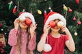 Merry Christmas. Portrait of two happy funny children girls in Santa hat with Christmas wreath Royalty Free Stock Photo