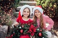 Merry Christmas. Portrait of two happy funny children girls in Santa hat with Christmas wreath Royalty Free Stock Photo