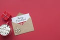 Merry Christmas red card top view. Envelope with wish, gift and mug of coffee on red background
