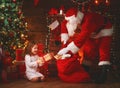 Merry Christmas! santa claus and child girl at night at the Chr Royalty Free Stock Photo