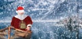 Merry christmas santa claus in a small vessel floating on a lake in a snowy cold winter landscape scenery