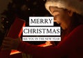 Merry christmas see you in the new year text over happy girl opening present in background Royalty Free Stock Photo
