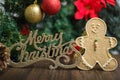 Merry Christmas sign with gingerbread man cookie and decorations on a Christmas tree. Royalty Free Stock Photo