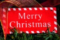 Merry Christmas sign hanging in the Christmas tree Royalty Free Stock Photo