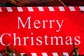 Merry Christmas sign hanging in the Christmas tree Royalty Free Stock Photo