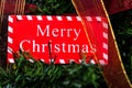 Merry Christmas sign hanging in the Christmas tree Royalty Free Stock Photo