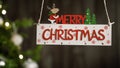 Merry Christmas Sign Hanging With Tree On The Background