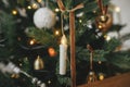 Merry Christmas! Stylish christmas candle on tree close up. Beautiful decorated christmas tree with vintage ornaments, ribbons and