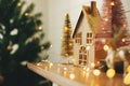 Merry Christmas. Stylish christmas wooden house, glitter christmas tree and golden reindeer in festive lights. Miniature fairy Royalty Free Stock Photo