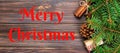 Merry Christmas text. Christmas background with fir tree and gift box on wooden table. Top view with copy space banner Royalty Free Stock Photo