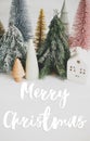 Merry Christmas text handwritten on christmas little houses and trees on white background,  winter holiday village scene. Greeting Royalty Free Stock Photo
