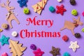 Merry Christmas text. New Year decorations on purple background. Festive stars and balls. Merry Christmas concept with Royalty Free Stock Photo