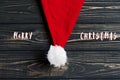 Merry christmas text sign on christmas santa hat on stylish bla Royalty Free Stock Photo