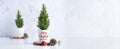 Merry christmas tree with pine cone,decor red xmas ball on wood log at white table and marble tile wall background.clean minimal Royalty Free Stock Photo