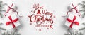 Merry Christmas Typographical on white background with gift boxes, fir branches, red decoration. Royalty Free Stock Photo