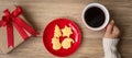 Merry Christmas with woman hand holding coffee cup and homemade cookie on table. Xmas eve, party, holiday and happy New Year Royalty Free Stock Photo