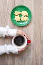 Merry Christmas with woman hand holding coffee cup and homemade cookie on table. Xmas eve, party, holiday and happy New Year Royalty Free Stock Photo