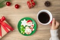 Merry Christmas with woman hand holding coffee cup and homemade cookie on table. Xmas eve, party, holiday and happy New Year Royalty Free Stock Photo