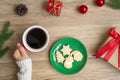 Merry Christmas with woman hand holding coffee cup and homemade cookie on table. Xmas eve, party, holiday and happy New Year Royalty Free Stock Photo