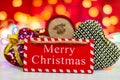 Merry Christmas wooden sign. Christmas composition on blurred lights background. Colorful Christmas balls Royalty Free Stock Photo