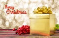 Merry Christmas word with Gold present box and ribbon on table w Royalty Free Stock Photo