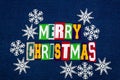 Merry Christmas word text collage typography, multi colored fabric on blue denim, paper snowflakes winter holiday Royalty Free Stock Photo