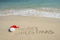 Merry Christmas written on tropical beach white sand with snowman Royalty Free Stock Photo