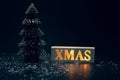 Merry christmas,xmas and celebration concepts with xmas lightbox text and pine tree on dark background