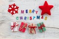 `Merry Chritsmas` letters, Christmas decoration and gift boxes on white wooden