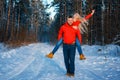 Merry couple having fun in the winter forest in red sweatshirts