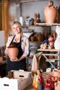 Merry female artisan having ceramics in workshop
