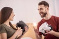 Merry glad couple holding VR headsets