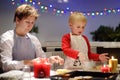 Merry little boy and his young grandmother bake cookies together during the holidays season. Christmas and New Year with kids Royalty Free Stock Photo