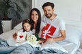 Beautiful woman with her husband and daughter posing in bed Royalty Free Stock Photo