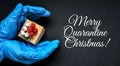 MERRY QUARANTINE CHRISTMAS text Holiday shopping. Festive gifts. Pandemic restriction. Winter shopping. Hand in protective gloves