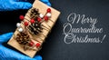 MERRY QUARANTINE CHRISTMAS text Holiday shopping. Festive gifts. Pandemic restriction. Winter shopping. Hand in protective gloves