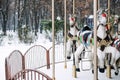 Merry-round-go Horse Carousel in winter park. Winter snow landscape with Retro carousel roundabout white horse. Off Royalty Free Stock Photo