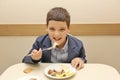 Merry schoolboy Sitting At Table In School Cafeteria Eating Meal. drinking juice - Russia, Moscow, the first High School, the firs Royalty Free Stock Photo