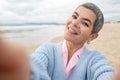 Merry senior woman taking selfie at beach