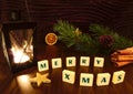 Merry Xmas words with flashlight candle, star, pine branch, cinnamon and orange