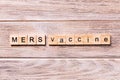 MERS vaccine word written on wood block. MERS vaccine text on wooden table for your desing, coronavirus concept top view