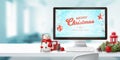 Mery Christmas on computer display and decorations on work desk Royalty Free Stock Photo