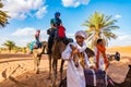 MERZOUGA, MOROCCO - August 02: A Berber male guide in traditional dress training a young male camel in the Erg Chebbi