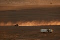 Merzouga, Morocco - December 04, 2018: camion autocaravana, y coche levantando polvo al atardecer en el desierto