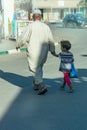 Merzouga. Morocco. October 3, 2019. Arab man walking from the hand of a girl