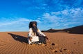 Merzouga, Morocco - October 16, 2018: Tuareg man meditating in the Erg Chebbi sand dunes in the Sahara Desert Royalty Free Stock Photo